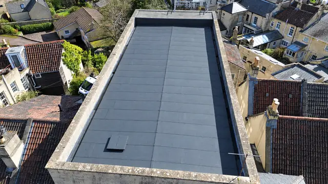 Overhead drone view of a new felt flat roof on a stone building
