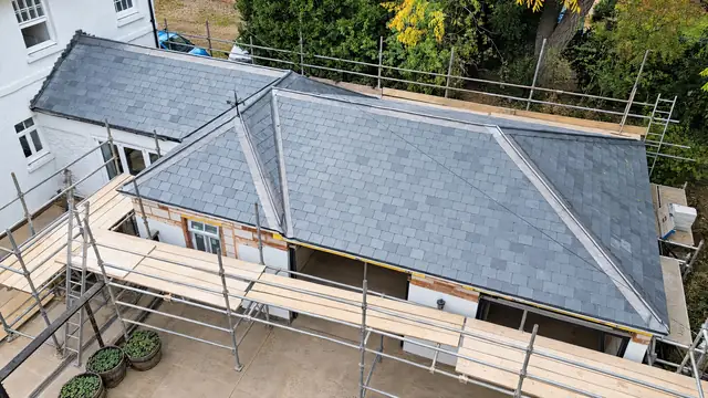 Aerial view of a natural slate hip roof with new lead hips, scaffolded during works