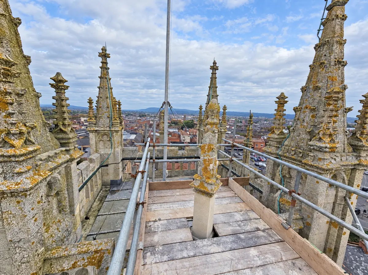 Scaffold access among the stone pinnacles of a church tower during heritage roofing work